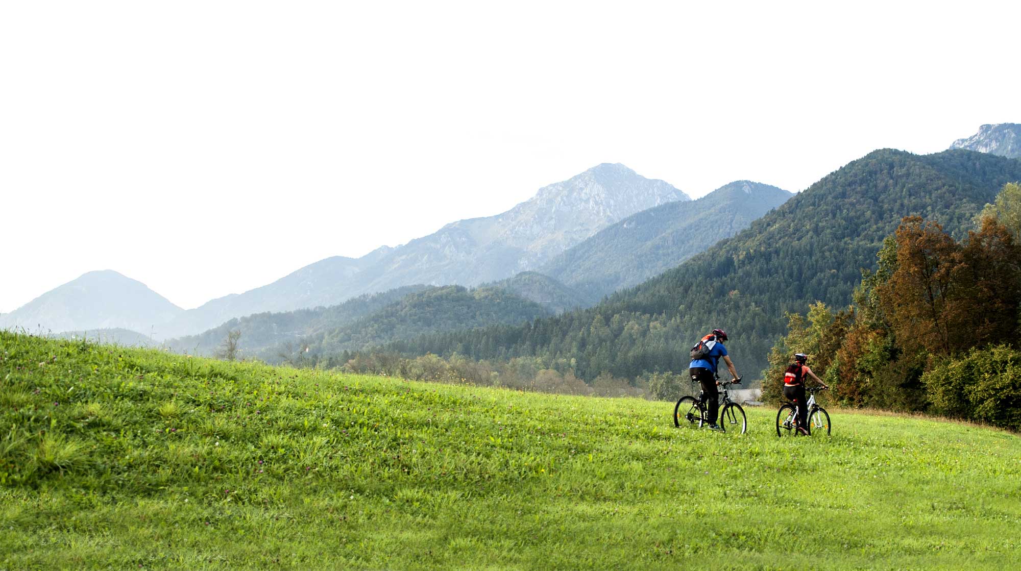 bnr-blue365 two people riding bikes through a grassy valley