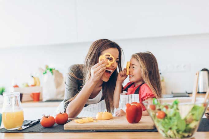 A woman and child cooking in a kitchen